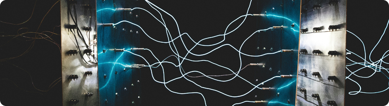 Capacitors and passive components on circuit boards linked by glowing blue wiring, illustrating AI infrastructure hardware.
